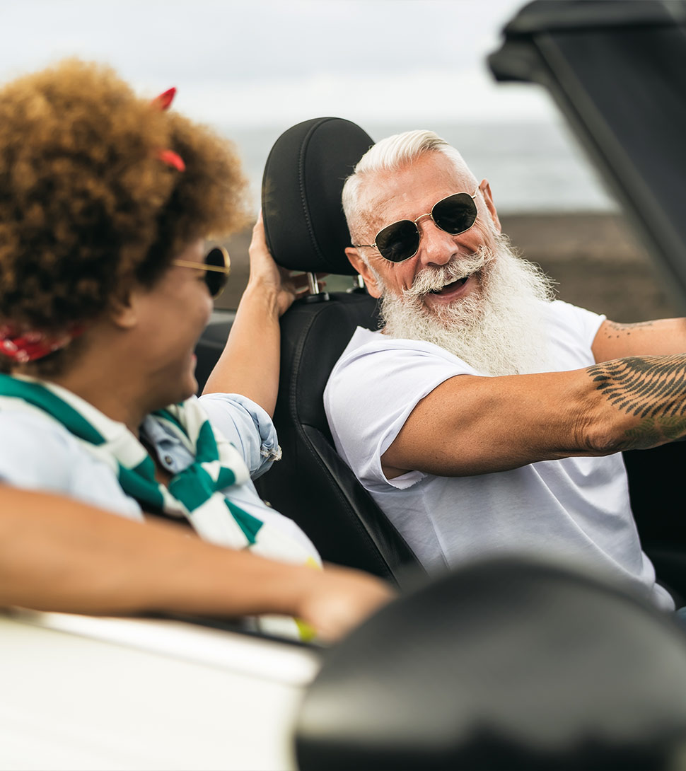 smiling senior couple driving in a convertible annuities for retirement